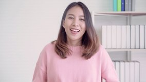 Young Asian friendly businesswoman speaker looking at camera and talking podcast on video shooting with technology. Social media influencer people or content maker concept in relax casual at house.