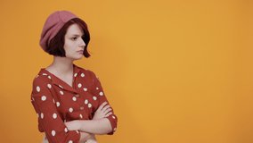 Beautiful brunette caucasian young lady wearing pretty red shirt with polka dot making unimportant and doubts gesture while lifting the shoulders on isolated yellow background