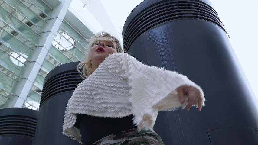 Passionate plus size blonde girl performing seductive dance outdoors, confidence