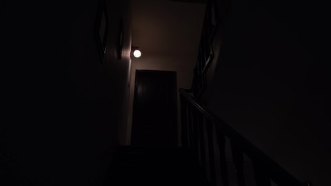 An unknown person goes upstairs slowly in a house