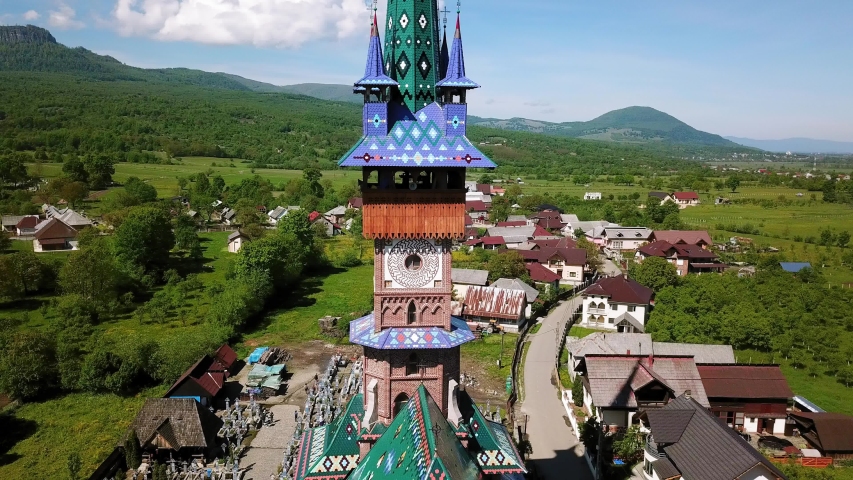 Aerial view of  Church in Merry Cemetery, Colored Tombstones with Spiritual and Merry Cemetery in Maramures, Romania, Decorated tombstones in the Merry Cemetery Royalty-Free Stock Footage #1040396969