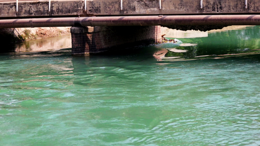 Flowing river under bridge during summer