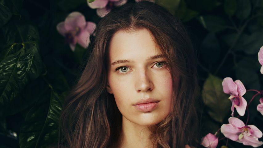 Beautiful girl among the plants and flowers of the archidea. Natural cosmetics and skin care. Exotic flower. Girl in jungle. Perfume Advertising. Royalty-Free Stock Footage #1040403191