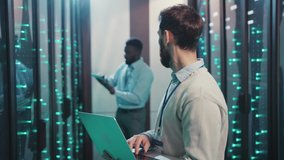Diverse server administrators cooperating in modern rack server cabinet room using laptop inspecting hardware system quality in data center. Information concept. - Powered by Shutterstock - Get 15% off with code: PIKWIZARD15