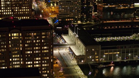 Boston Massachusetts Aerial Wide cityscape view to birdseye near Seaport Boulevard at night - October 2017