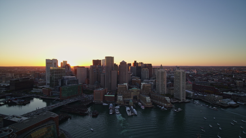 Boston Massachusetts Aerial Flying over waterfront downtown skyline at sunset looking toward the Charles River - October 2017