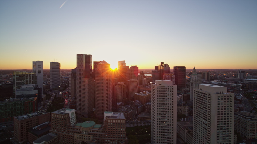 Boston Massachusetts Aerial Flying over waterfront downtown skyline at sunset looking toward the Charles River - October 2017