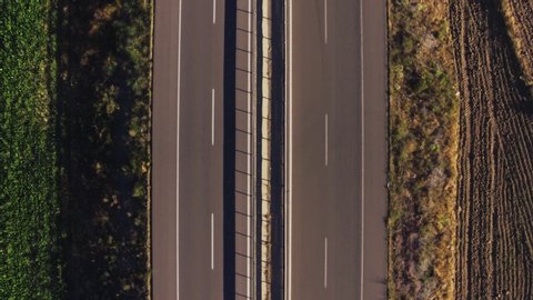 Empty endless autobahn road / two sided double way asphalt highway in dry rural landscape at summer sunny day / Aerial drone top view