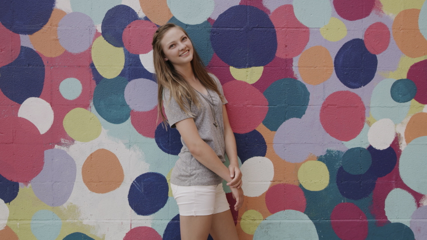 Portrait of laughing girl posing near dotted wall / Provo, Utah, United States