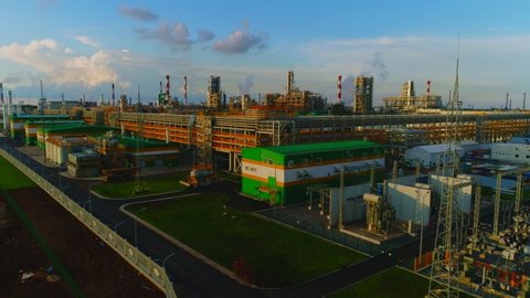modern gas and oil refinery complex with tanks and complicated pipeline system under blue sky with clouds aerial view