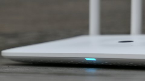 White Wireless Wi-Fi Router On The Grey Desk Panning Slider Shot.