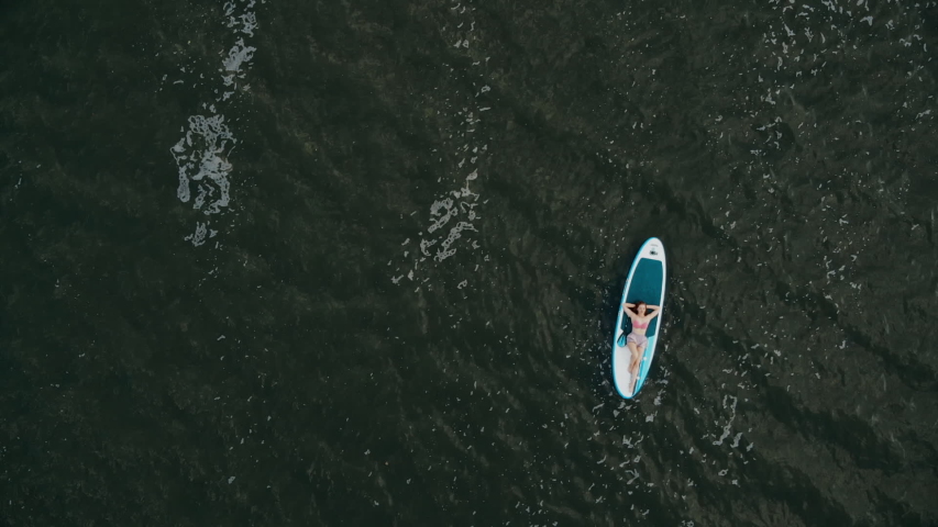 Young woman relax on a sup Board. Aerial view
