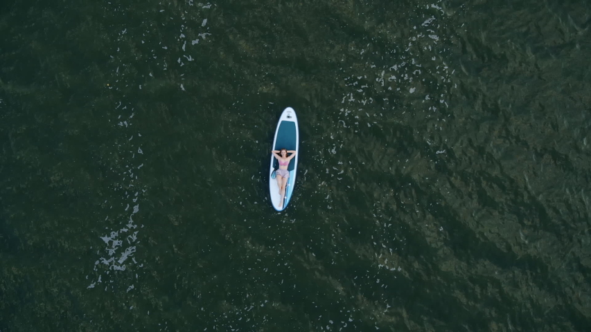 Young woman relax on a sup Board. Aerial view