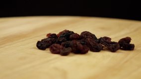 a handful of raisins rotates 360 degrees on a black background