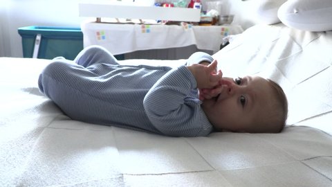 Cute toddler baby infant layed in bed happy.