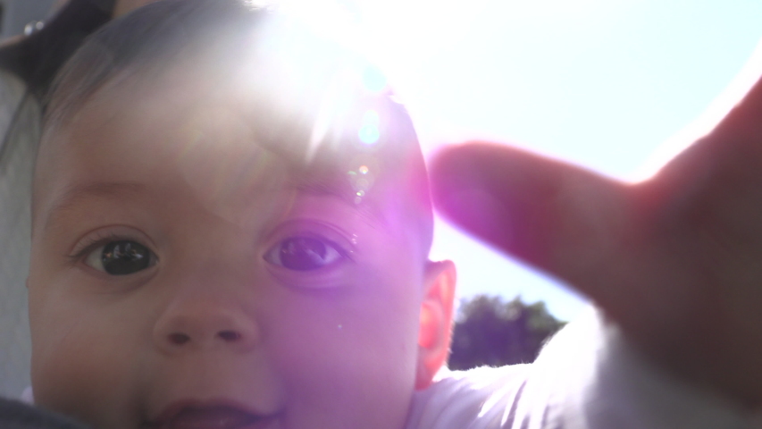 
Adorable baby face portrait outside with lens-flare