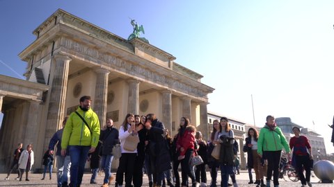 THE BRANDENBURG GATE, BERLIN, GERMANY – 18 FEBRUARY 2019, Tilt down to people, tourists and students during the day by The Brandenburg Gate, Berlin, Germany