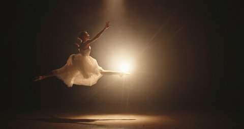 Female ballet dancer performing on spotted stage, douing various movements and pirouettes - arts, success concept 4k footage