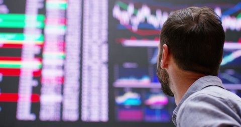 4k Happy and cheerful businessman checking stock market data at a stock exchange floor.