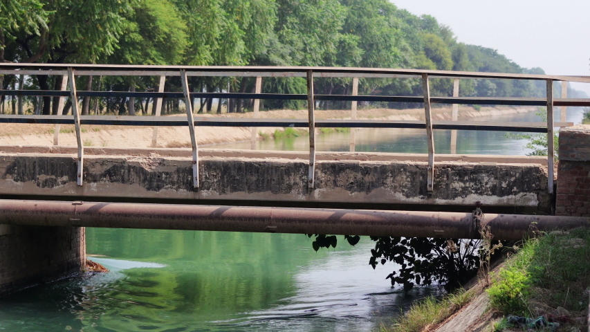 Flowing river under bridge during summer