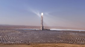 Solar power tower and mirrors that focus the sun's rays upon a collector tower to produce renewable, pollution-free energy, Aerial footage.