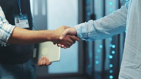 Close-up business people server engineers shaking hands of agreement welcoming partnership working together in rac server room of data center. Collaboration concept. - Powered by Shutterstock - Get 15% off with code: PIKWIZARD15