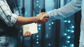Close-up server engineers business people shaking hands cooperating agree on successful deal of partnership staying in server room of data center. - Powered by Shutterstock - Get 15% off with code: PIKWIZARD15