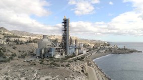 Stock video

Aerial view of heavy industry cement factory buildings. Industrial area with silos next to the sea. Air and  sea pollution  global warming, climate change, construction concept