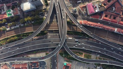 Overhead aerial view of freeway intersection and railway line in Qingdao, urban infrastructure development in China
