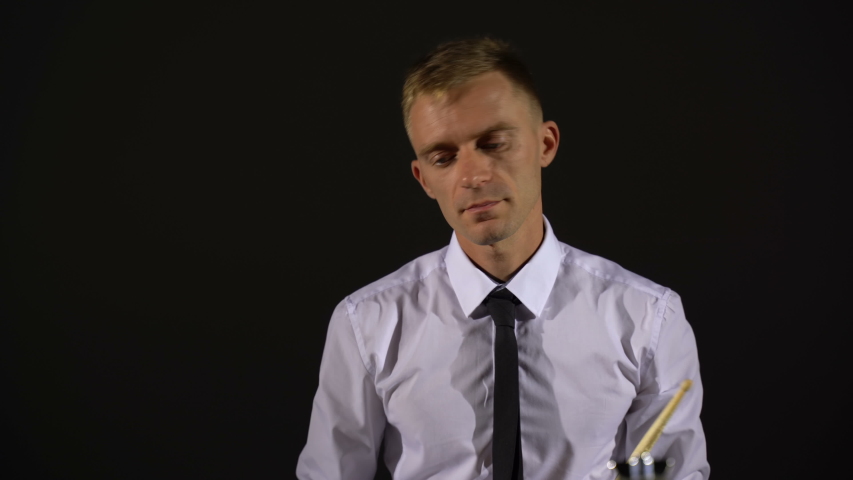 The guy plays with chopsticks on the drums. Close-up shot
