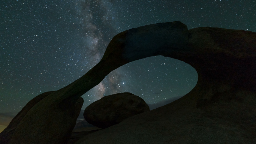 Astro timelapse of night to day transition of Milky Way galaxy through Mobius Arch in Alabama Hills in Sierra Nevada Mountains, California 