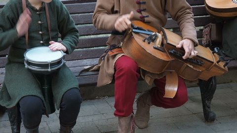 Street musicians dressed in vintage ethnic oriental clothes play music on traditional Middle Eastern musical instruments turkish darbuka and hurdy-gurdy