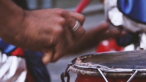 Male Hands holding Drum Sticks while Playing Traditional Drum. Close-Up. Filmed in Latin America. 