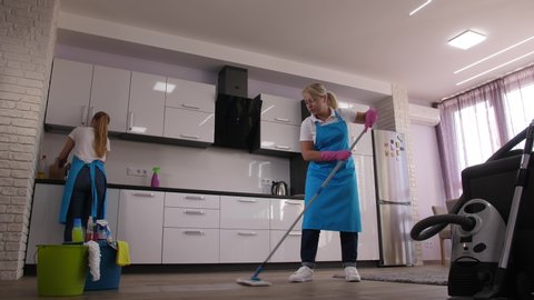 Time lapse of home cleaning services, cleaning ladies mopping floor, vacuuming carpet, washing sink, wiping kitchen surfaces in apartment. Skillful employees of cleaning company during work