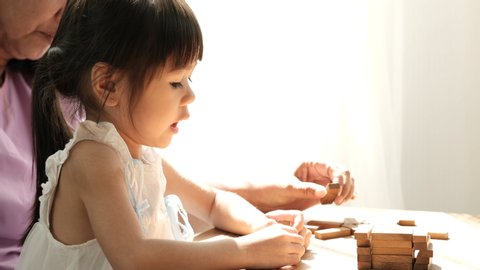 Little Asian girl plays toys together with her grandmother with day light and look fun with family. : vidéo de stock