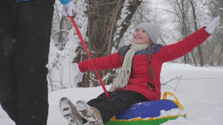 child and mother sledding in the snow. Daughter and mom play in the winter park on Christmas holidays. family winter vacation. happy childhood concept