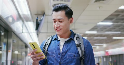 asian young man use 5g smartphone on the mrt station