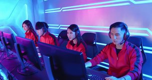 Team of asian teenage cyber sport gamers win the multiplayer PC video game on eSport tournament and cheer with hand up