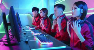Team of asian teenage cyber sport gamers wear headsets on and play in multiplayer PC video game on eSport tournament