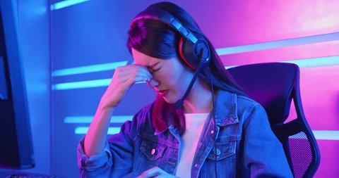 Young asian esport gamer girl feel painful while playing in Online Video Game because her eye is tired