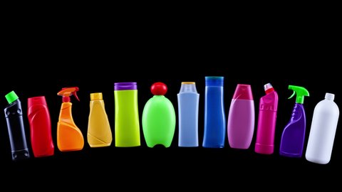 Plastic waste bottles in rainbow colors slide in and explode, pollution and clean up concept - black background