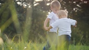 Happy family: funny slow motion video little kid boy hold hands play whirl a and girl brother and sister hold hand on nature happy children concept. children happy family boy girl slow motion video