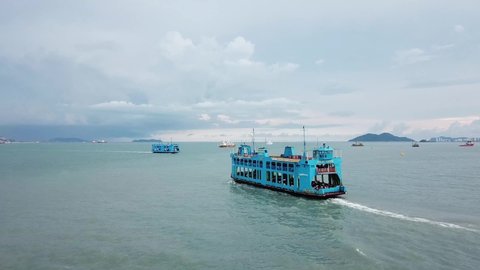 George Town, Penang/Malaysia - May 04 2019: Two blue ferry move in different direction. Background is Penang Bridge.