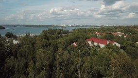 4K Baltic Sea Gulf of Finland lagoon and green forest view bright sunny summer day aerial video, upmarket neighborhood and vintage Lutheran church in country capital in northern Europe