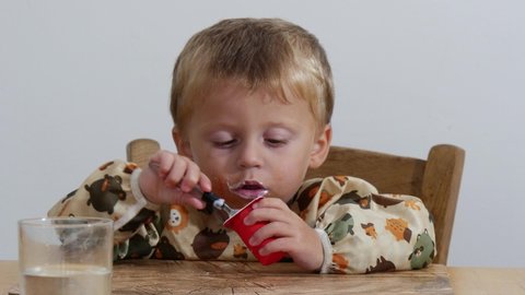 two years old boy eating a yogurt