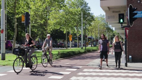 Rotterdam / Netherlands - September 15, 2019 : Pedestrians and cyclists crossing at a traffic light controlled street crossing