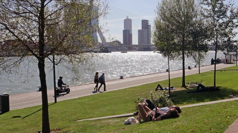 Rotterdam / Netherlands - September 15, 2019 : People in park area at the riverside of the River Rotte enjoying sunny warm weather