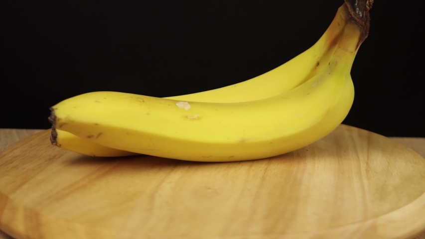 2 bananas rotate 360 degrees on wooden stand