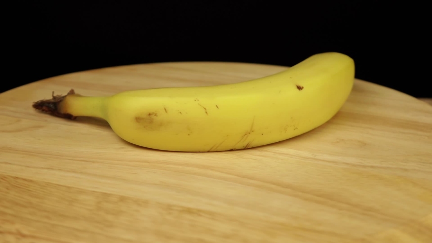 yellow banana rotates 360 degrees on a wooden stand