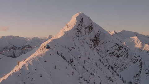 Sunset in snowy mountains drone shot